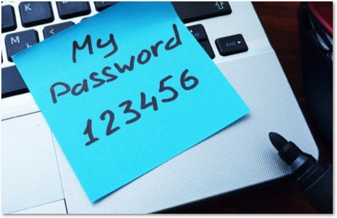 Blue sticky note on the edge of a laptop keyboard with My Password 123456 written on it in black marker