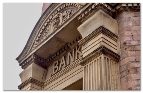 imposing front entrance of a bank with ornate header and wide columns