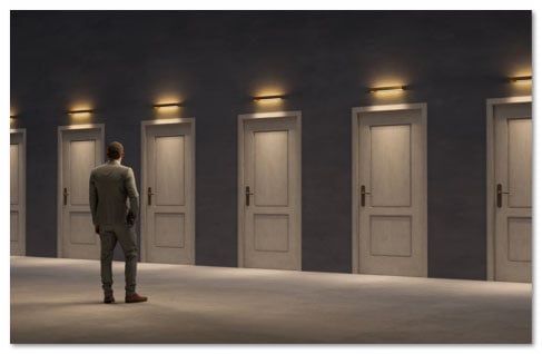 Man in a suit looking at a row of 6 identical clsoed white doors