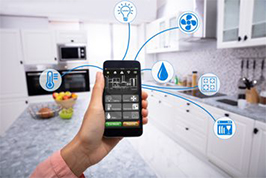 Segurando um celular aonde aparecem ícones conectados a vários dispositivos da casa habilitados para a internet