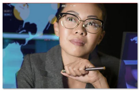 Woman in glasses with a large wall map behind her