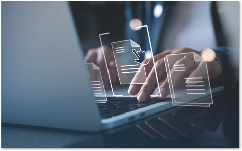 Hands on a laptop keyboard with document icons floating in front