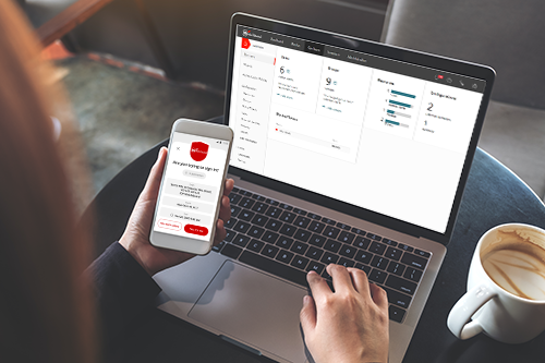 Person using their phone to authenticate to their laptop with AuthPoint MFA