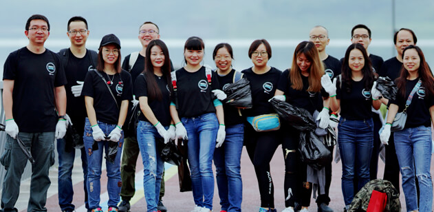 Gruppo numeroso di dipendenti WatchGuard che indossa attrezzatura per la pulizia