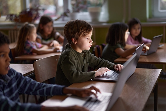 De jeunes élèves utilisent des ordinateurs portables en classe