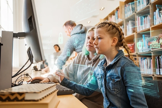 Des enfants utilisent un ordinateur dans une bibliothèque scolaire