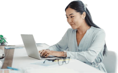 Woman working on a laptop at a white desk