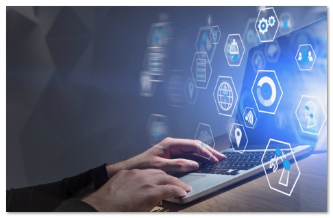 Hands on a laptop keyboard with glowing blue icons projected in front of the screen