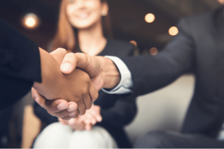 CSR - People shaking hands in front of a smiling woman