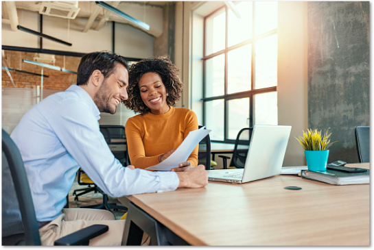 Man and a woman working at a wooden desk