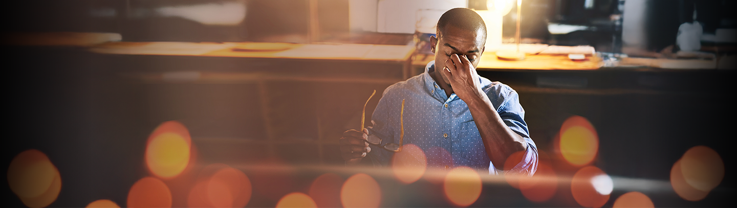 Frustrated man rubbing his face with one hand