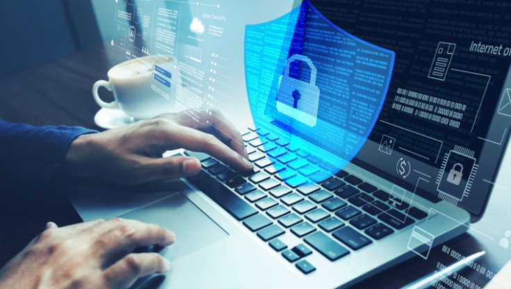 Hands typing on a laptop with a digital shield and lock overlay, representing network security.