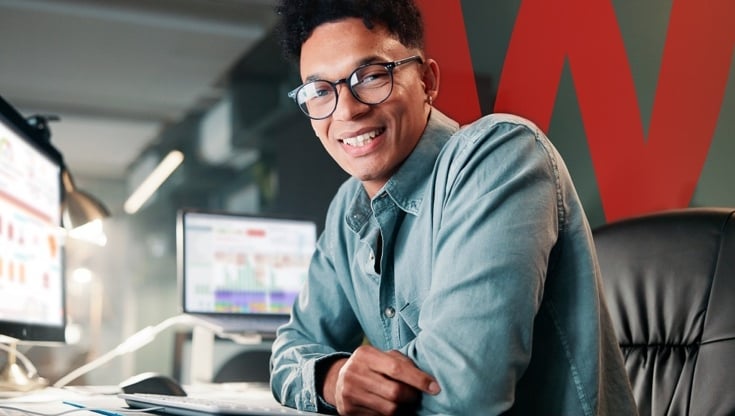 man smiling at camera with endpoint server software on his computer