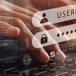 Hands typing on a laptop keyboard with digital login screen overlay showing username and password fields, symbolizing cybersecurity and account protection.