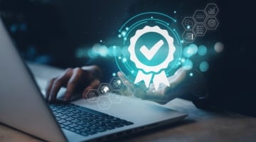 Cybersecurity compliance concept showing digital certification shield and secure network on laptop, representing CMMC requirements for defense contractors