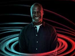 Smiling black man surrounded by rings of blue and red lights