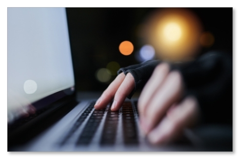 Hands wearing gloves typing on a keyboard