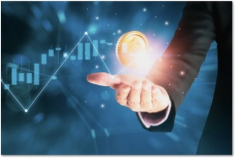 Large gold coin floating above a man's open palm with a chart behind it