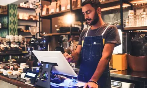 Man working at a shop counter at a small computer