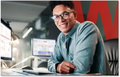 Smiling man in glasses at his desk