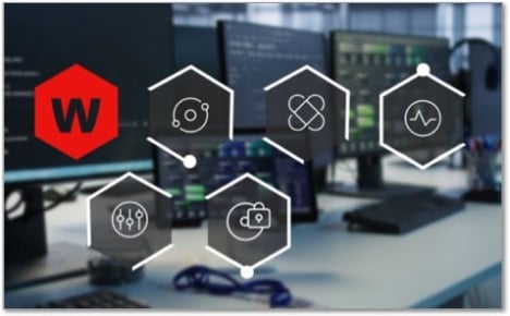 Icons in hexagon shapes floating in front of a row of monitors on a desk