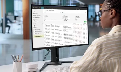 Person looking at a list of network endpoint devices on a large monitor