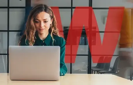 Woman in a green shirt working at a laptop