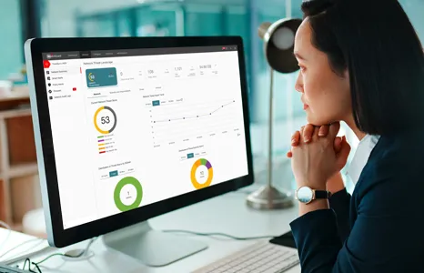Woman looking at a WatchGuard Cloud dashboard on a monitor