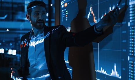 Man in a suit presenting in a dark meeting room