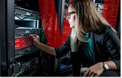 blonde woman reaching for a red Firebox in a server rack