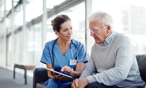 Doctor showing something to an older gentleman on her tablet