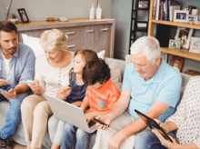 A large family sitting together on a couch on different mobile devices