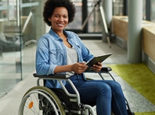 Black woman in a wheelchair holding a tablet computer