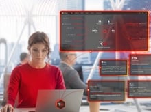 Woman in red working at a laptop with dashboard screens floating around her