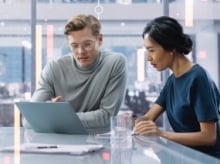 co-workers looking at a laptop screen together