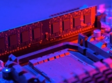 Red lit circuit inserted into a purple and blue lit motherboard