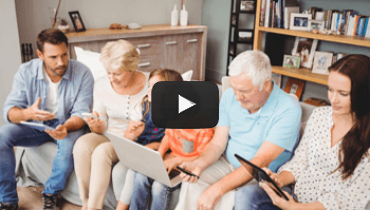 A large family sitting together on a couch on different mobile devices