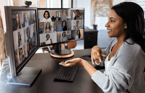 Woman on a video chat with two screens of co-workers' faces showing