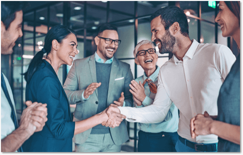 Business people standing in an open air lobby, shaking hands and chatting