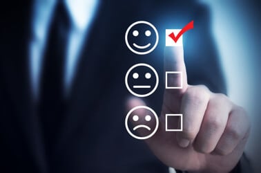 Smiley face rating system with the happiest face checked with a red checkmark