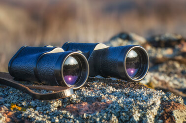 binoculars sitting on a rocky ledge